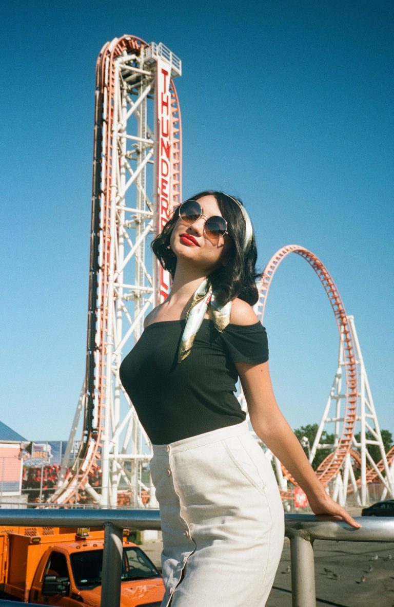 attractive woman in front of roller coaster